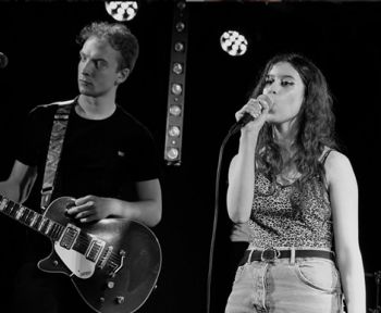 Rania Bouzekraoui singing on stage with a guitarist