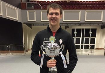 James Meekin standing and holding a silver cup