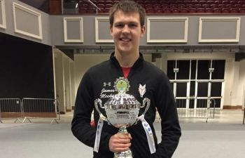 James Meekin standing and holding a silver cup
