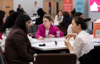 Attendees sat in discussion at a table at a Make it Happen networking event in the Student Centre.