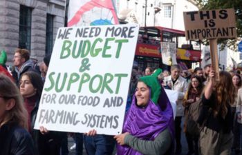 Crowd of Landworkers Alliance members marching with signs in London in 2022 to demand food and climate justice