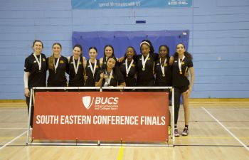 a women basketball team posing with their trophy