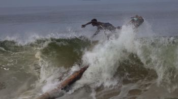 Richard, a fisherman from Thiruvananthapuram in southwestern India jumps off his kattamaram raft to escape high waves. A still from Crashing Waves, by Vincy Lopez