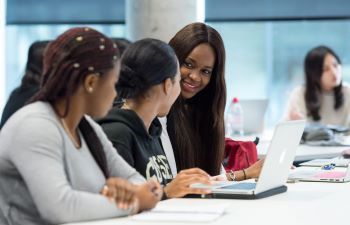 Three female students talking in a class