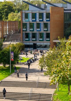 Students walking outside the Jubilee Building in summertime; leaves are visible on the trees