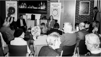 Black and white image of the audience facing Carole Bennett and Feras Alkabani at the Silk Road event