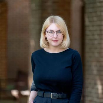 Decorative - Kate Marrison stands infront of brick archway and smiles for camera