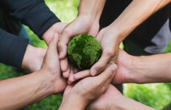 Group of adults holding a green globe