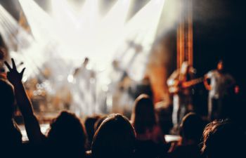 Blurred image of dancers at concert stage in back ground