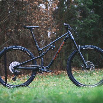 a mountain bike parked in front of a forest