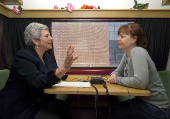 Two women, one talking, one listening, with tape recorder