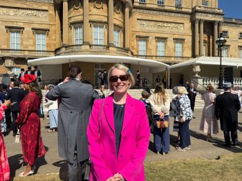 Prof Claire Smith wearing a pink blazer in the Royal Garden at Buckingham Palace