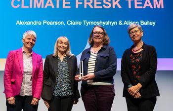 Climate Fresk Team- Winners of Environmental Sustainability. Alison Bailey and Alexander Pearson accepting an award on stage at the Sussex Awards.