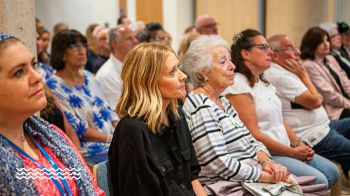 Rows of audience face forward, listening and engaging