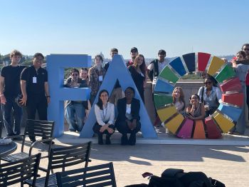 students on a sunny terrace with the UN FAO logo