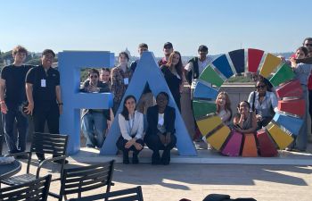students on a sunny terrace with the UN FAO logo