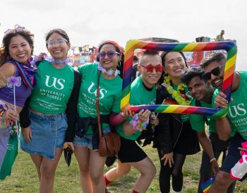 A group of people with green t shirts at Brighton Pride smiling at the camera