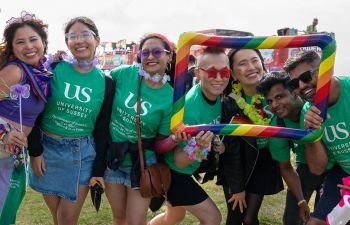 A group of people with green t shirts at Brighton Pride smiling at the camera