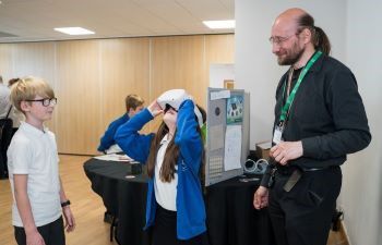 Two students using virtual reality headsets with Dr Daniel Creed