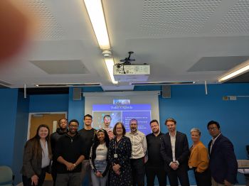 group of CIPFA and Business School staff faculty and students in seminar room in front of projector screen