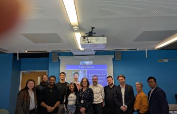 group of CIPFA and Business School staff faculty and students in seminar room in front of projector screen