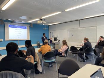 lecture in action with slide show and students seated in seminar room
