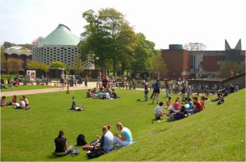 Groups of people on a grassy bank in front of the Meeting House