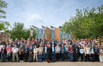 Attendees of WIN25 conference standing outside in a large group in front of a building