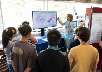 Students gathering round and looking at an exhibition at the Sussex Drug Discovery Centre