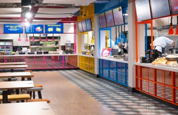 An image showing Eat Central eatery on the University of Sussex Campus, featuring tables, chairs and plants.