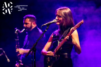A woman and a man playing musical instruments on stage