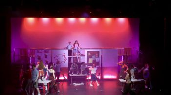 Performers singing and dancing on stage