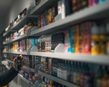Vapes and e-liquids on rows of shop shelves