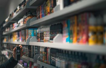 Vapes and e-liquids on rows of shop shelves