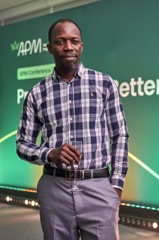 Man standing holding a glass wearing a check shirt