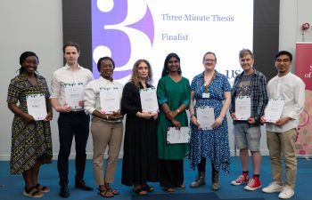 Three Minute Thesis (3MT) 2025 finalists standing together holding their certificates and smiling.
