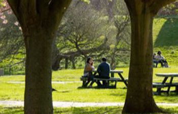 Two individuals sat at a campus picnic table