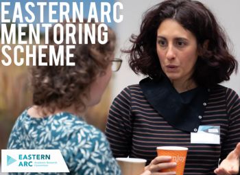 Two women talking at the Eastern Arc Mentoring scheme event holding coffee cups