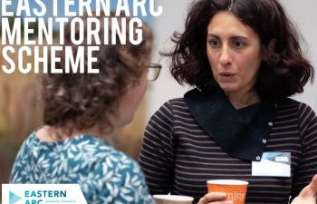 Two women talking at the Eastern Arc Mentoring scheme event holding coffee cups