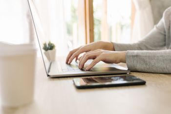 Hands typing on a laptop.