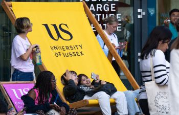 Students taking selfies in a giant University of Sussex deckchair