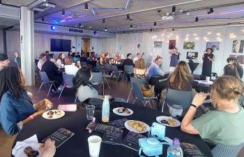 Attendees  at round tables listening to speakers at the launch event