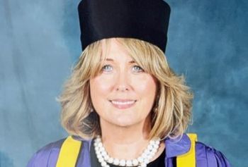 Caroline Lehany in a graduation gown and hat smiling at the camera