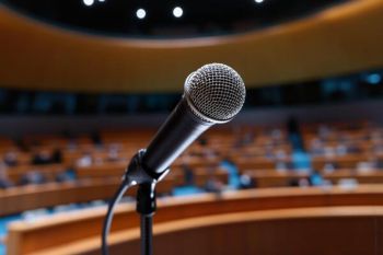 A speaker's view of a microphone, facing out into a large lecture theatre