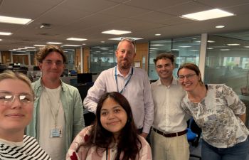 Sustainability team members pose for a photo stood together in an office