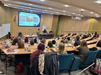 A photograph showing a busy lecture theatre being addressed by a speaker at the conference 'Discussing Death and Loss in the Classroom'