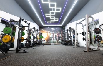A photo of the new University of Sussex gym located in the Sports Centre. Photo shows gym equipment and colourful lighting.
