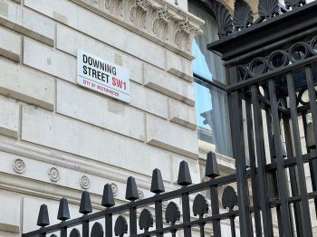An image of a public wall/corner on which is attached the Downing Street sign