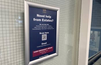 A photo of a QR code reporting poster in an academic building