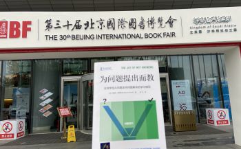 A photograph of the entrance to The 30th Beijing International Book Fair with the Chinese version of 'The Joy of Not Knowing' in the foreground